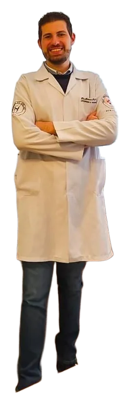 Dr. Marcos Paulo Vanzin em pé, de jaleco branco e braços cruzados, sorrindo